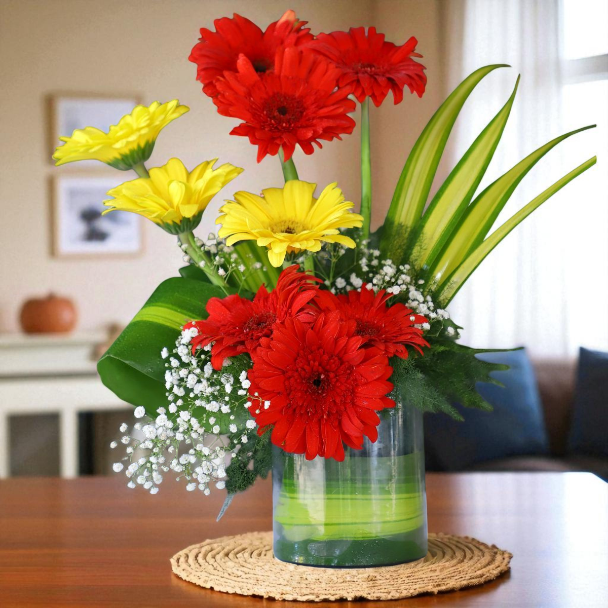 Red and yellow gerbera vase arrangement with fillers and greens