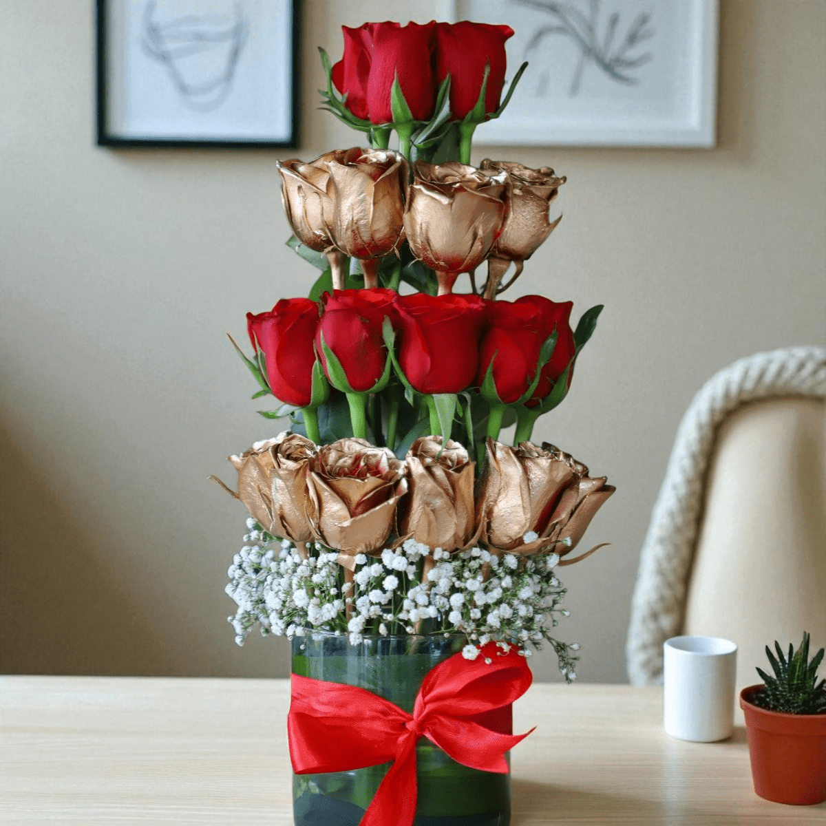 Golden and red roses vase arrangement with layered design and ribbon bow