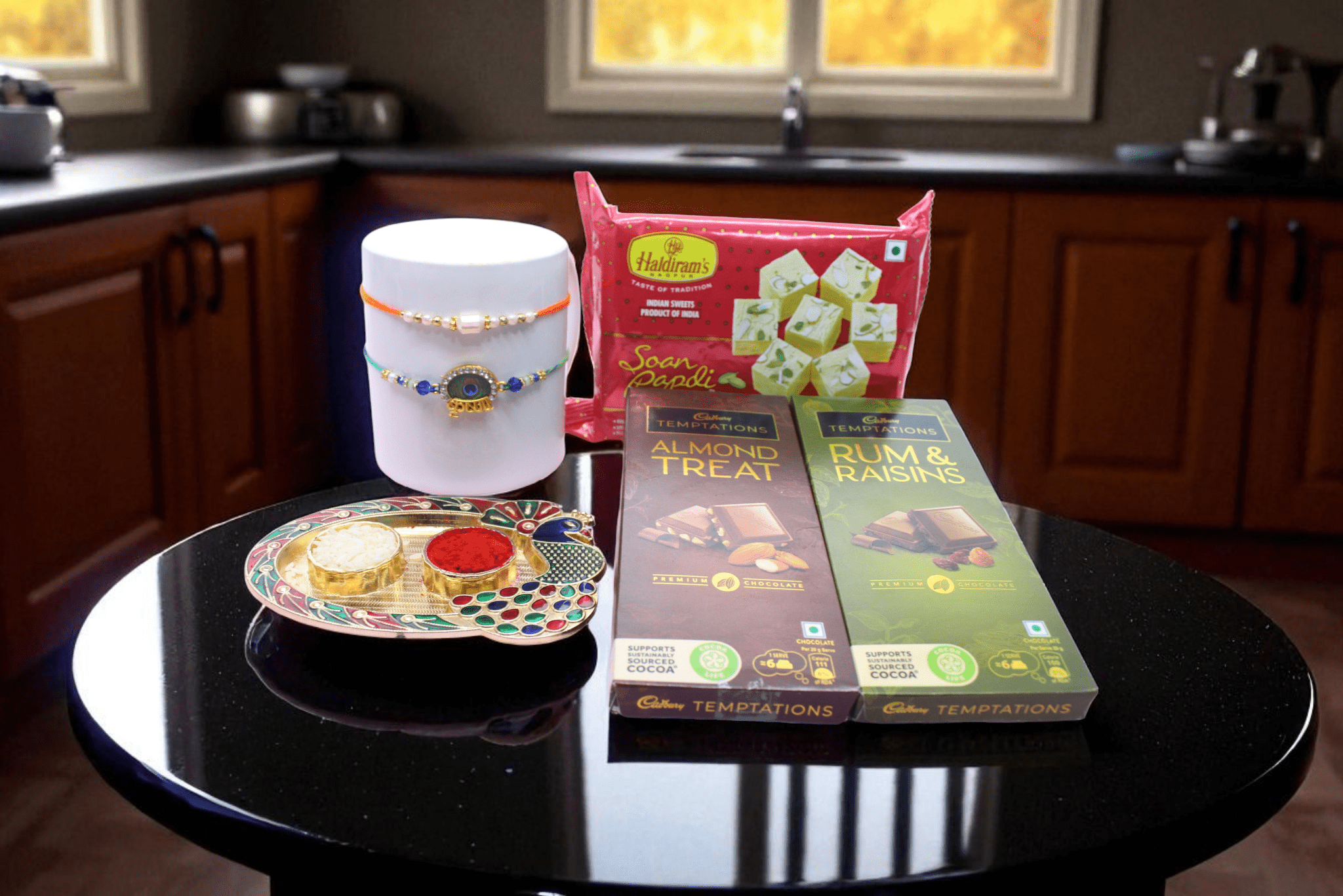 Rakhi With Chocolate & Sweet a Krishna Rakhi, a graceful Pearl Rakhi, two premium Cadbury Temptations chocolate bars & Soan Papdi - YHOJA.COM