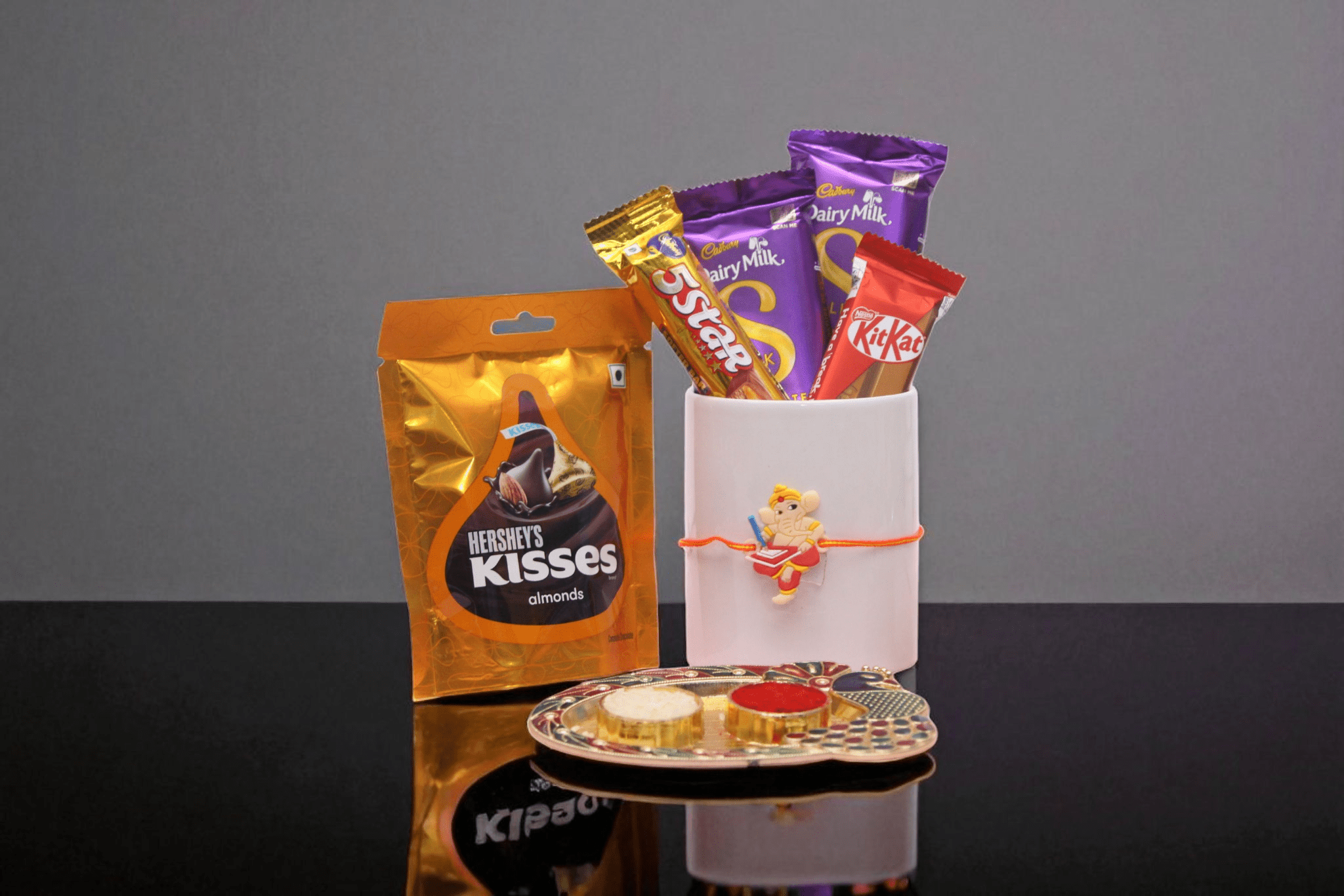 Chhota Ganesh Rakhi with Chocolate Chhota Ganesh Rakhi, Dairy Milk Silk, 5 Star, KitKat, and a luxurious Hershey’s Kisses Almonds pack - YHOJA.COM