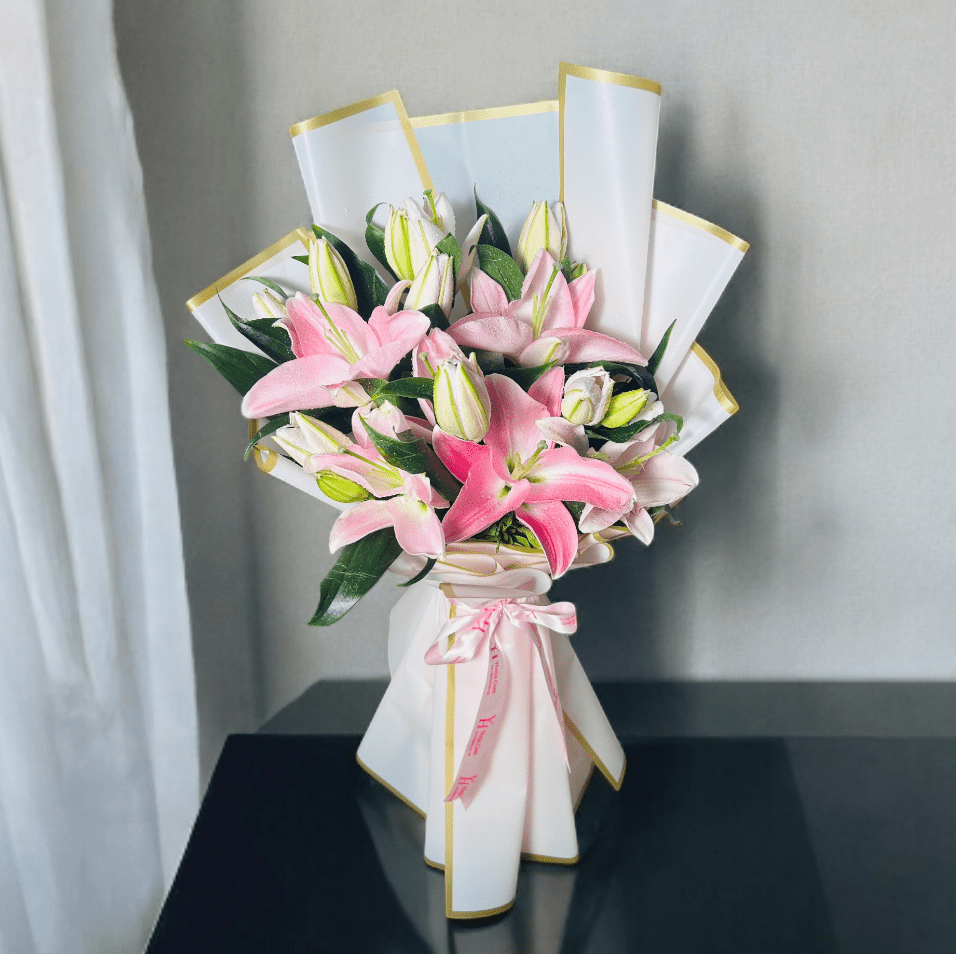 Pink oriental lily bouquet wrapped in premium white paper with ribbon bow